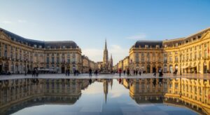 The Place de la Bourse in Bordeaux, France, with its grand 18th-century buildings reflected perfectly in the shallow waters of the Miroir d'eau.